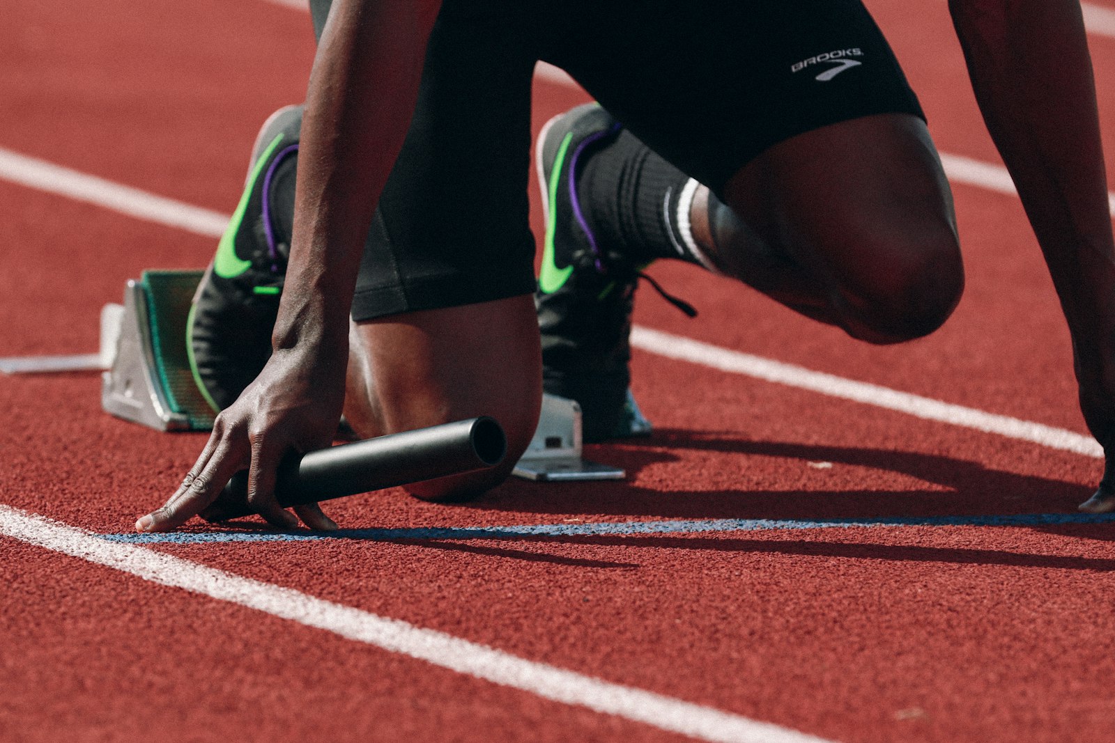 Atleet in de startblokken op de baan