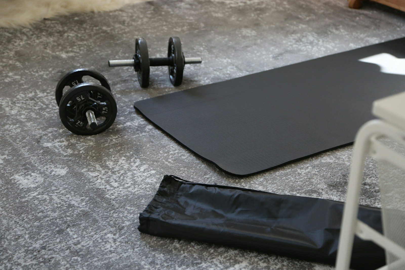 Dumbbells en een oefenmat op de vloer
