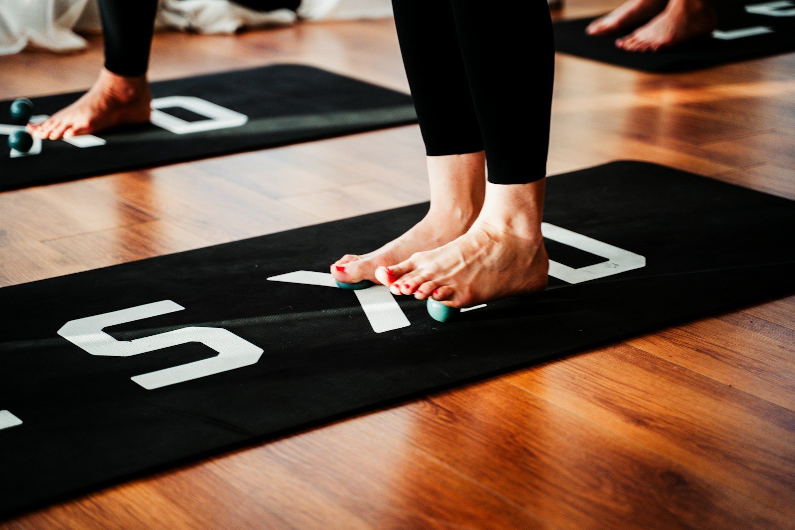Voeten op een sportmat met massageballetjes onder de voetzool