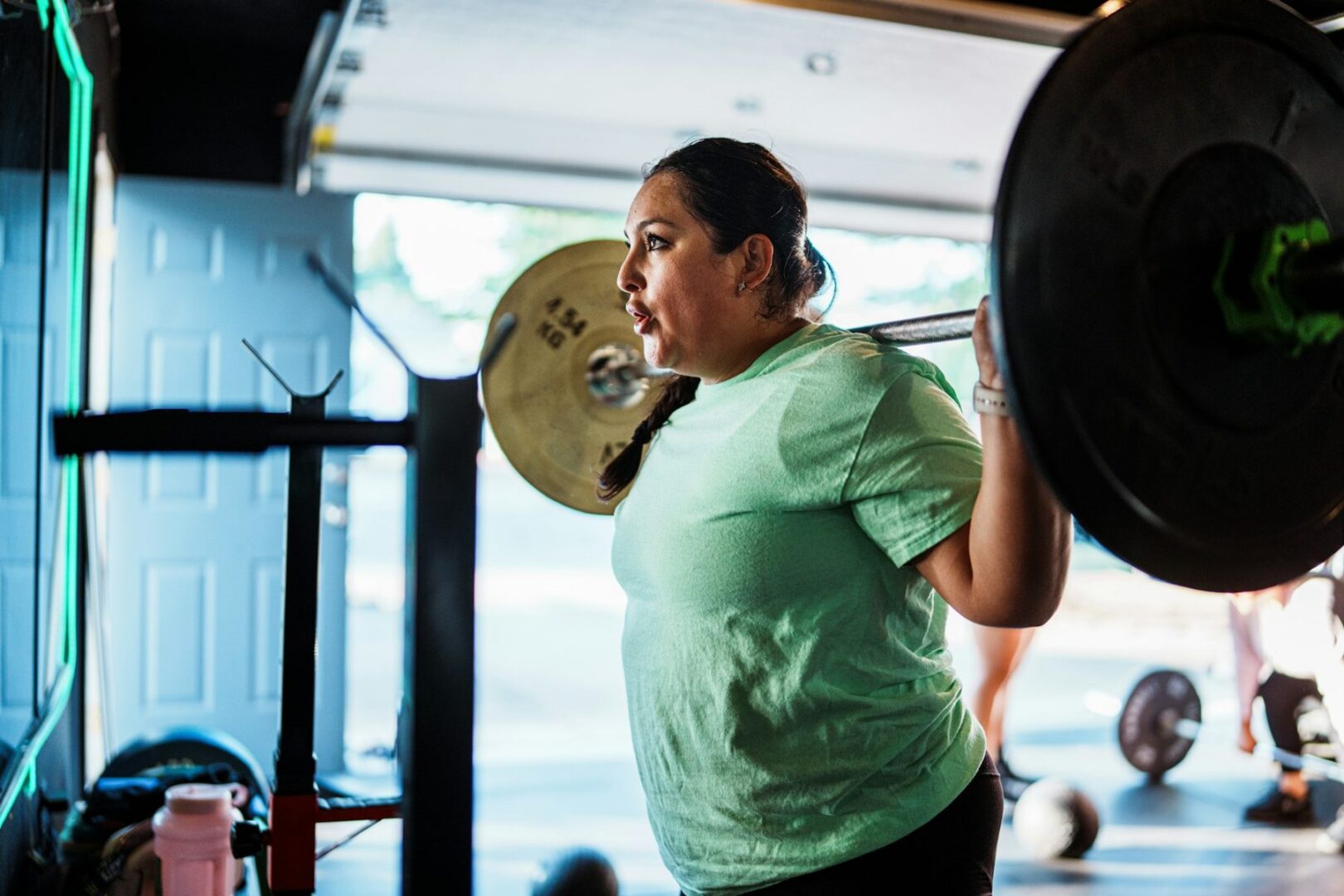 Vrouw doet een squat met een halter