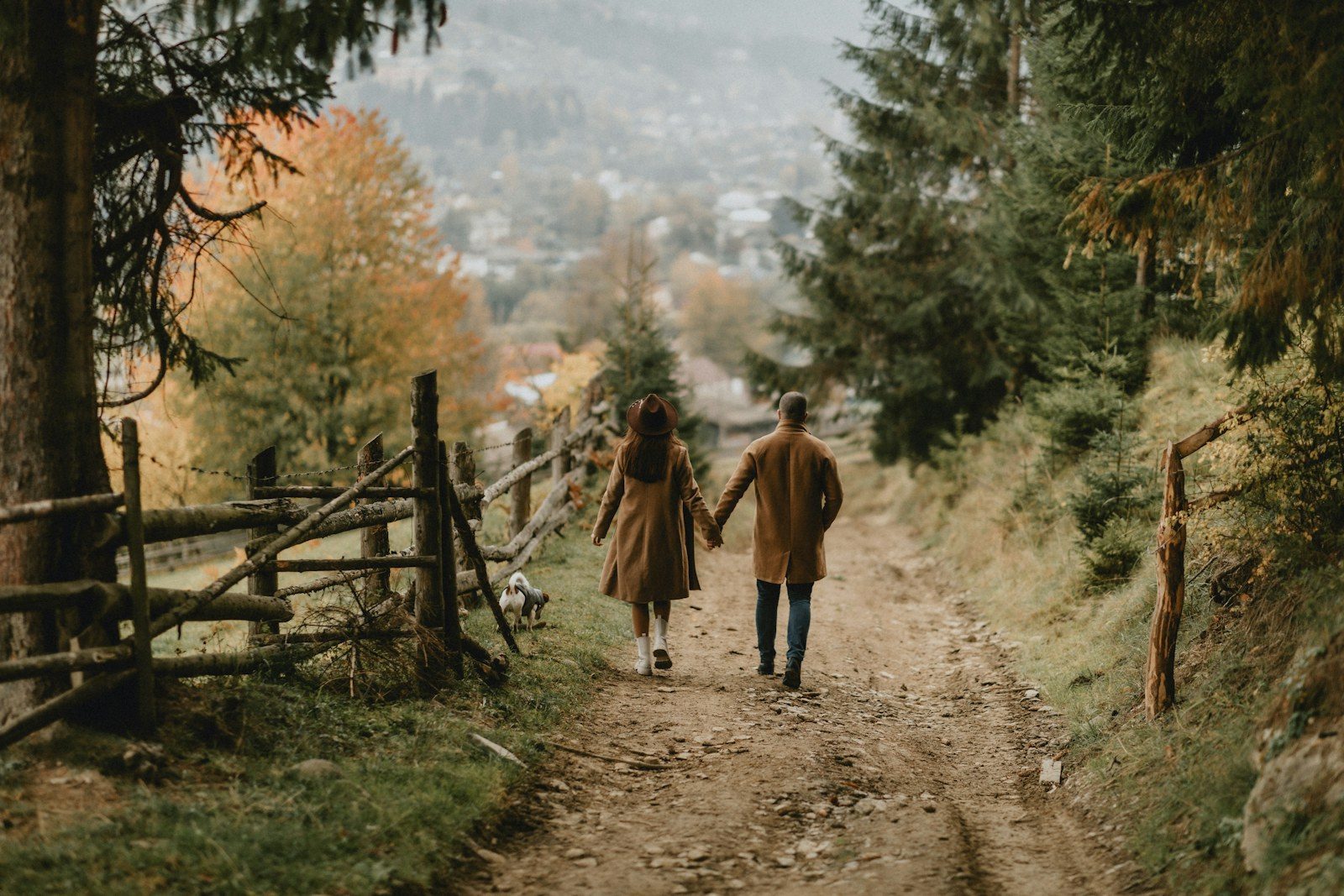 Twee mensen wandelen samen over een bospad in de herfst