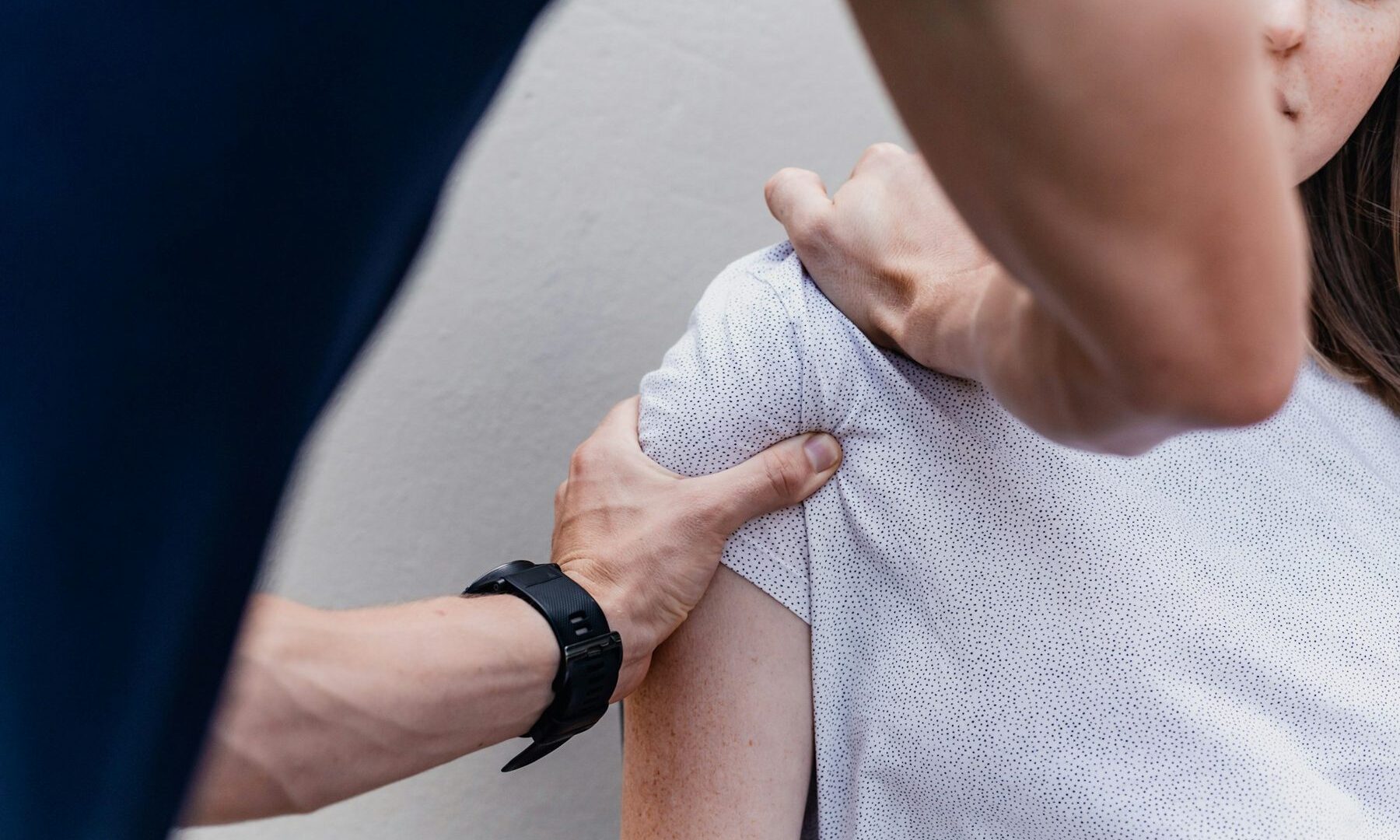 Fysiotherapeut onderzoekt de schouder van een cliënt